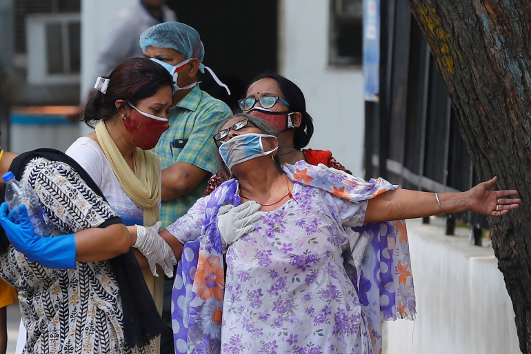 A woman mourns after seeing the body of her son who died due to the coronavirus disease, outside a mortuary of a COVID-19 hospital in New Delhi